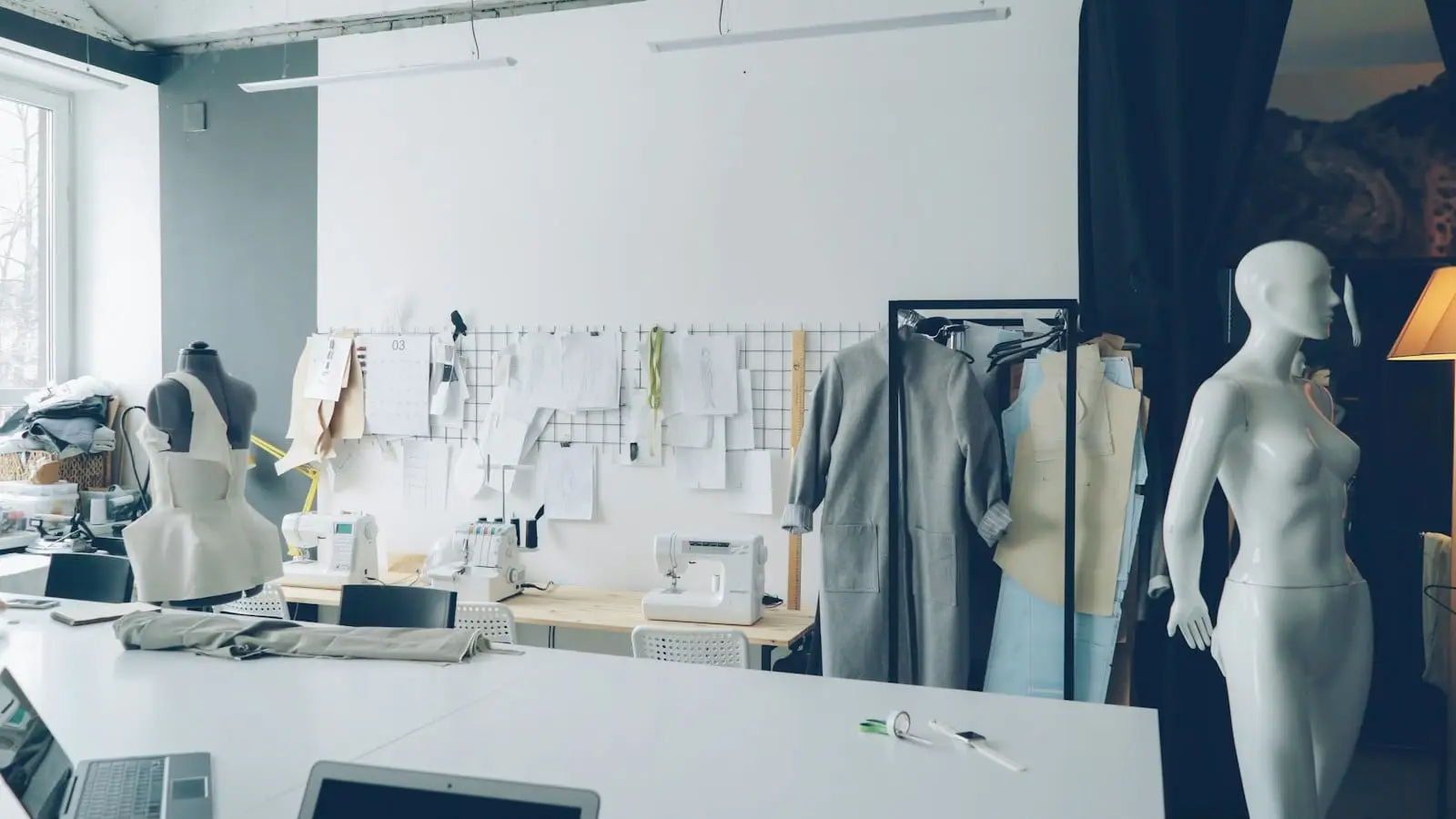 A fashion design studio with mannequins, a clothes rail and sketches